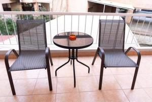 2 chaises et une table en verre sur un balcon dans l'établissement Central appartment3 with parking, à Larissa
