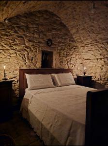 1 dormitorio con 1 cama grande en una pared de piedra en Parlami d'amore Mariù, en Modugno