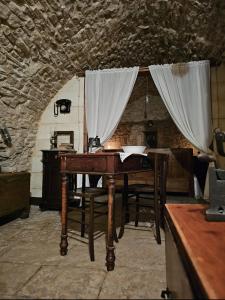 - un bureau en bois dans une chambre avec rideau dans l'établissement Parlami d'amore Mariù, à Modugno