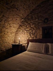 - une chambre avec un lit dans un mur en pierre dans l'établissement Parlami d'amore Mariù, à Modugno
