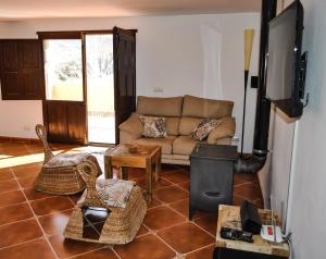 a living room with a couch and a television at Casa La Sorpresa in La Ermita del Piar