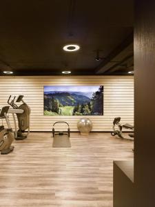 einen Fitnessraum mit einem großen Gemälde an der Wand in der Unterkunft Hotel & Restaurant STERNEN MURI bei Bern in Bern