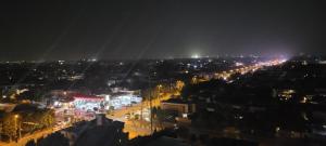 vista di una città di notte con luci di Goldcrest Luxury Apartments a Lahore