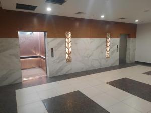 a lobby with a marble wall and a elevator at Goldcrest Luxury Apartments in Lahore