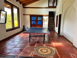uma mesa de pingue-pongue no meio de uma sala em Casa de eventos y descanso em La Calera