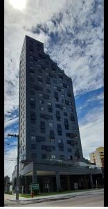 un edificio alto en la esquina de una calle en Ilusion hotel ponta negra Natal, en Natal