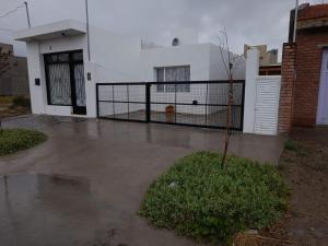 a fence in front of a house with a tree at KaVa in Rawson