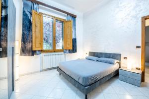1 dormitorio con 1 cama y 2 ventanas en Camera 'Dolphin' - eleganza e tranquillità, en Florencia