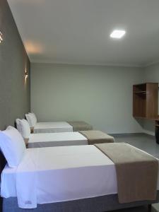a row of beds in a room at Pousada Vivenda in Olímpia +7 photos