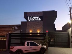 a white truck parked in front of a building at Pousada Vivenda in Olímpia