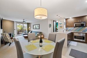 Una cocina y una sala de estar con mesa y sillas. en Brooks Beach Vacations Villa C205 Oceanside, en Oceanside