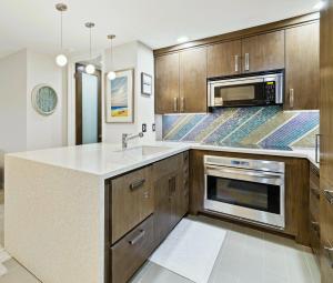 una cocina con fregadero y microondas en Brooks Beach Vacations Villa C205 Oceanside, en Oceanside