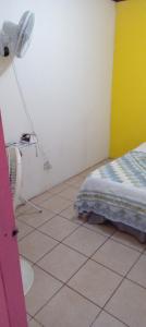 a room with a bed and a table with a fan at Apartamentos HJJ in Puerto Limón