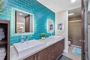 baño con 2 lavabos y pared de azulejos azules en Brooks Beach Vacations Villa C205 Oceanside, en Oceanside 21 fotos más