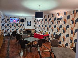 a dining room with tables and chairs and a tv at Hostal Luna de Nerja in Nerja