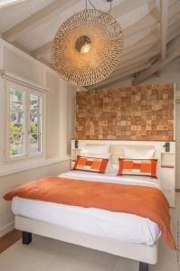 um quarto com uma cama grande e um lustre grande em La Suite Villa em Les Trois-Îlets