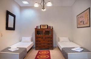 ein Zimmer mit zwei Betten und einer Kommode in der Unterkunft Feneri Traditional House Apt 1- 20' from Elafonisi beach in Elafonisi