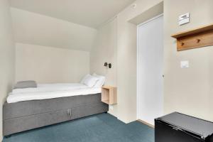 um pequeno quarto com uma cama e um armário em Central Guest House - Bedroom with en suite Bathroom em Stavanger