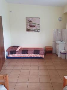 ein Schlafzimmer mit einem Bett auf einem Fliesenboden in der Unterkunft MeeMo 1 - hostel dla Firm in Łyszkowice
