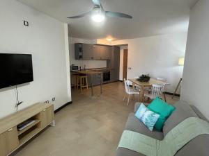 Casa Teri - Los Lagos في كوتيو: غرفة معيشة مع أريكة وتلفزيون ومطبخ
