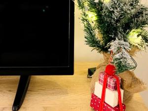 un christmas présent sur une table à côté d'un arbre de Noël dans l'établissement KEZA's Apartment - Strasbourg, à Strasbourg