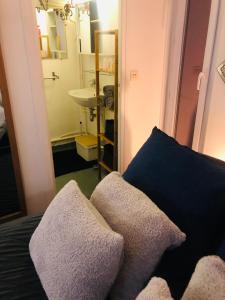 baño con lavabo y 2 almohadas en una cama en Habitation CASSIOPEE en París
