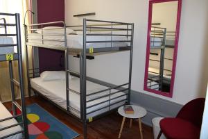 a room with three bunk beds and a mirror at By Doors Hostel in Porto
