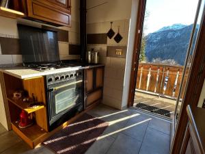 una cucina con piano cottura e una grande finestra di My Dolomites Home a Livinallongo del Col di Lana