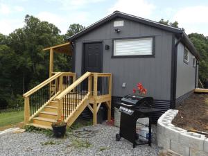 a tiny house with a porch and a staircase at The Ranch in Mt Airy in Mount Airy