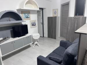 sala de estar con sofá azul y TV en Nina's house 3 , a 300 metri dal mare, en Santa Caterina Dello Ionio Marina