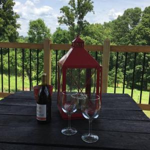 un tavolo con due bicchieri e una bottiglia di vino di The Ranch in Mt Airy a Mount Airy