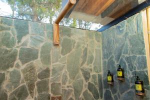 eine Steinmauer mit drei Flaschen darauf in der Unterkunft Glamping en Guatape Wifi Jacuzzi in Guatapé + 27 Fotos