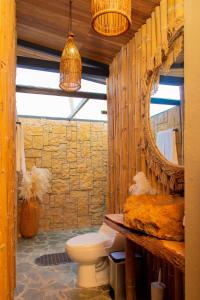 ein Badezimmer mit Toilette und Spiegel in der Unterkunft Glamping en Guatape Wifi Jacuzzi in Guatapé