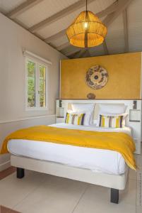 a bedroom with a large bed and a chandelier at La Suite Villa in Les Trois-Îlets