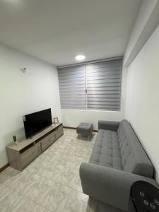 a living room with a couch and a flat screen tv at Apartamento Diagonal a Hesperia y Dunas in Naguanagua
