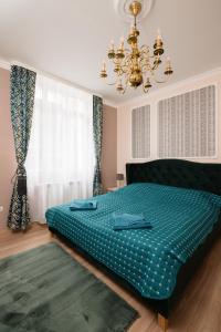 Un dormitorio con una cama verde y una lámpara de araña. en Serdika Old City House, en Sofía