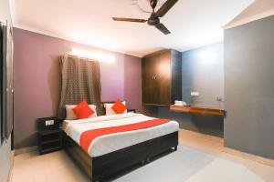 een slaapkamer met een bed met oranje kussens bij Hotel River Front in New Delhi