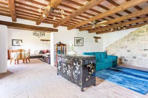 a living room with a blue couch and a stone wall at Luxury Villa with Pool, Stunning Location in San Ginesio