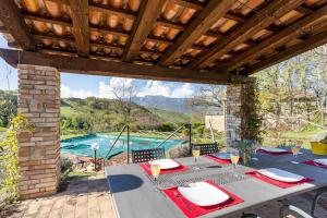 un patio con una mesa y una piscina en Luxury Villa with Pool, Stunning Location, en San Ginesio