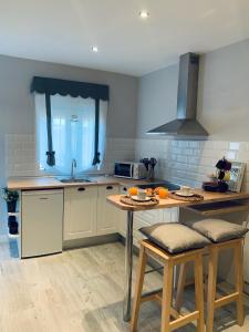 a kitchen with a sink and a table with chairs at Apartamentos Nenufar in Alhama de Aragón +20 photos