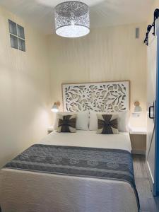 a bedroom with a large white bed with a chandelier at Apartamentos Nenufar in Alhama de Aragón