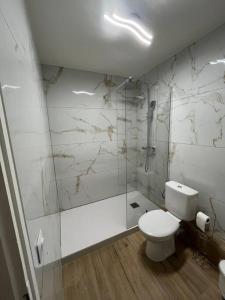 a white bathroom with a toilet and a shower at Joli appart/Vue étang/Clim /Wifi in Balaruc-les-Bains +23 photos