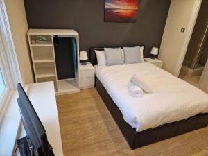 um quarto com uma cama grande com lençóis brancos em Tranquil Studio Apartment em Blandford Forum