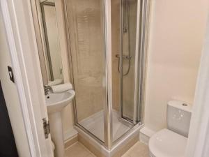 um banheiro com chuveiro, vaso sanitário e pia em Tranquil Studio Apartment em Blandford Forum