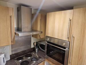 uma cozinha com uma placa de fogão e armários de madeira em Tranquil Studio Apartment em Blandford Forum