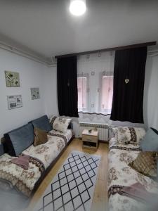 a living room with two couches in front of a window at Stan na dan Goran Pale in Pale