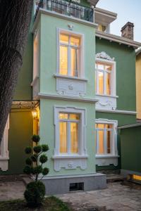 una casa verde con un árbol delante en Serdika Old City House, en Sofía