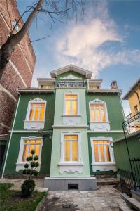 una casa verde con puertas naranjas en un edificio en Serdika Old City House, en Sofía
