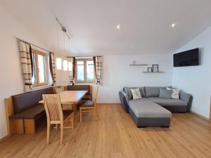 sala de estar con mesa, sofá y comedor en Sonnseit Appartement, en Sankt Veit im Pongau