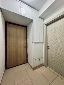een hal met een houten deur en een kast bij Monika's Apartment in Skopje
